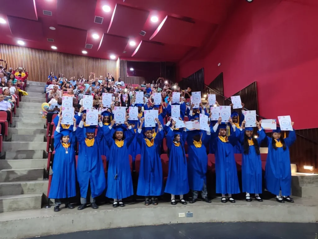 Niños de transición sosteniendo su diploma, cada uno con una gran sonrisa. 